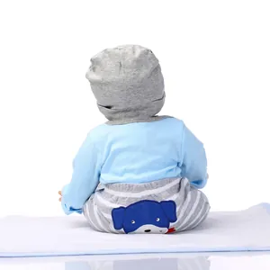 Detail of lifelike baby doll wearing blue top and striped pants with dog embroidery
