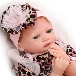 Realistic reborn baby doll girl in leopard print outfit with pink bow headband