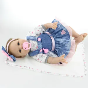 Lifelike reborn baby doll in denim pinafore dress with floral top and accessories