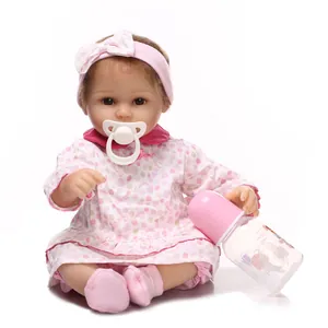 Realistic reborn baby doll in pink polka dot dress with pacifier and nursing bottle
