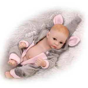 Realistic reborn baby doll in pink hooded animal outfit on soft white plush background