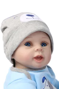 Close-up of lifelike reborn baby doll face with blue eyes and grey bear knit hat