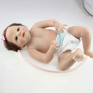 Realistische Reborn-babypop met bruin haar en roze strik op een displaymat