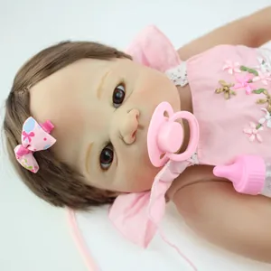 Realistische reborn babypop meisje met bruin haar, roze bloemenjurk en baby accessoires
