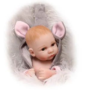Realistic reborn baby doll in grey plush animal hoodie on soft white fur background