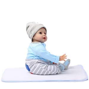 Detailed close-up of a realistic reborn baby doll wearing a blue outfit and grey hat