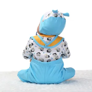Rückansicht einer lebensechten Babypuppe mit blauem Overall und passender bedruckter Mütze