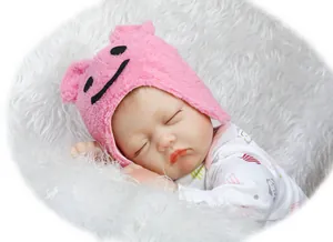 Close-up of a realistic sleeping reborn baby doll wearing a pink knit hat and printed romper