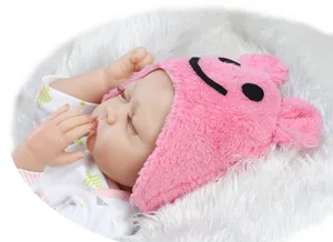 Close-up of a sleeping reborn doll with realistic eyelashes and pink plush cartoon hat