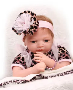 Close-up of lifelike reborn doll with blue eyes, leopard outfit and floral headband