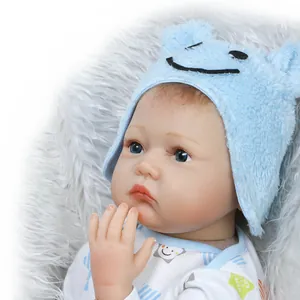 Close-up of realistic newborn baby doll face with soft blue bear hat and long eyelashes