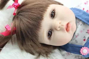 Close-up of lifelike baby doll with brown hair, pink bows, and realistic facial details