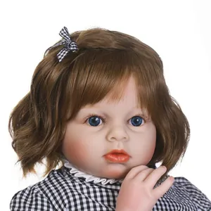 Lifelike reborn toddler girl doll with brown hair and checkered bow on white background