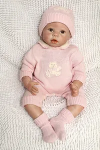 Vue détaillée d'une poupée Reborn en tenue tricotée rose avec broderie d'ours
