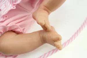 Close-up of realistic newborn doll feet showing detailed skin texture and fabric