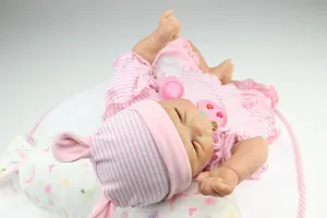 Close-up of lifelike baby reborn doll in striped outfit with a feeding bottle