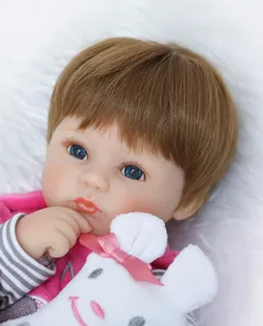Dettaglio di una bambola realistica con occhi azzurri e un coniglietto di peluche