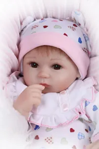 Gros plan d'une poupée réaliste avec yeux marrons et tenue rose à motifs cœurs