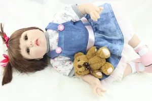 Detailed view of reborn baby doll in floral outfit with matching plush teddy bear