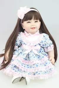 Realistische Reborn babypop met lang bruin haar en een blauwe bloemenjurk met kant