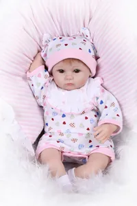 Vue détaillée d'une poupée reborn réaliste avec tenue rose à cœurs sur tapis en peluche