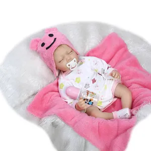 Sleeping reborn baby doll in pink bear hat and white star romper with feeding set