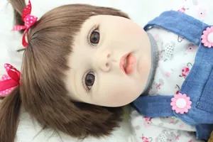 Close-up of lifelike baby doll face with hand-applied eyelashes and red bow hair clips