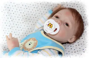 Realistic reborn baby doll with brown hair and blue lion outfit with magnetic pacifier