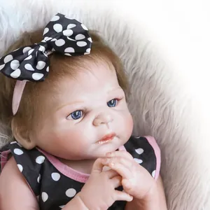 Close-up of lifelike doll with blue eyes and polka dot dress on soft plush background