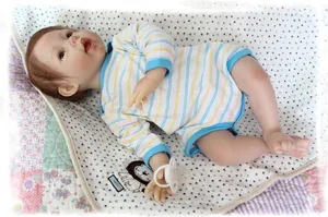 Macro detail of lifelike reborn doll wearing striped onesie with a white pacifier
