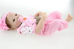 Detail of realistic reborn baby doll with pink cupcake outfit and flower headband