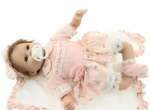 Detailed top view of realistic reborn baby doll in pink floral dress and headband