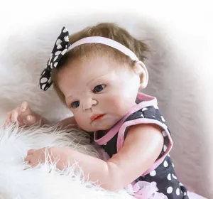 Close-up of realistic reborn baby doll with blue eyes and polka dot dress on fur mat