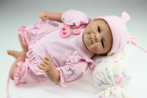 Detailed close-up of realistic reborn doll in striped outfit on a soft floral pillow