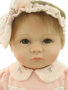 Close-up of lifelike baby doll face with detailed eyelashes and floral headband