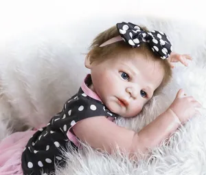 Detail of reborn baby doll featuring realistic skin texture and polka dot dress