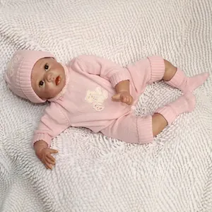 Poupée bébé Reborn réaliste avec tenue en tricot rose sur fond de fausse fourrure