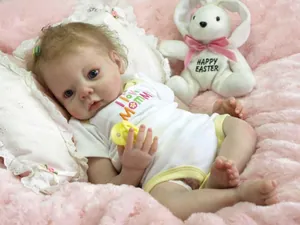 Realistic reborn baby doll with blonde hair and blue eyes wearing I love Mommy onesie