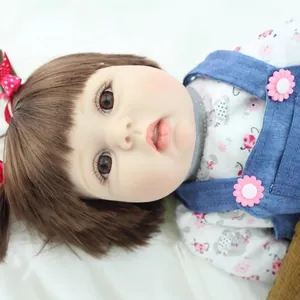 Lifelike reborn baby doll toy for girls featuring realistic skin texture and floral denim outfit