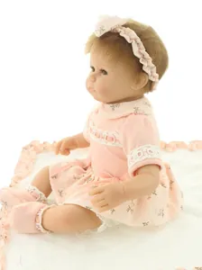 Detailed view of lifelike baby doll wearing pink floral dress and matching headband