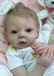 Close-up of a realistic reborn baby doll showing detailed skin texture and blue glass eyes