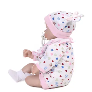 Détail de poupée reborn avec tenue à cœurs, chapeau à nœud rose et sucette