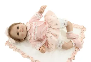 Detail of reborn baby doll in pink floral lace dress with matching floral headband