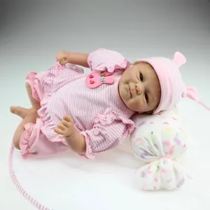 Realistic reborn baby doll in pink striped outfit with cute bunny pattern on studio background