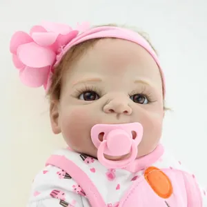 Realistic Reborn baby doll with pink floral headband, pacifier and cupcake outfit