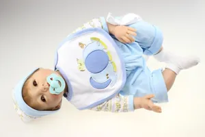 Detailed macro shot of realistic reborn doll wearing blue elephant bib and soft hat