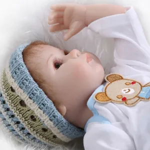 Close-up of reborn baby doll with long eyelashes and a striped hand-knitted hat