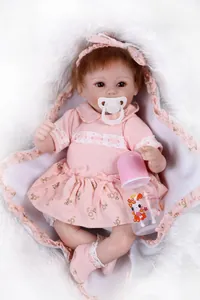 Detail of reborn baby doll in pink floral lace dress with pacifier and feeding bottle