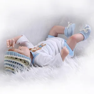 Detailed view of reborn baby doll in hand-knitted clothes on a soft white plush background