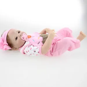 Lifelike Victoria baby doll with pink bow headband and cupcake outfit on white background
